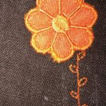 Leinenstoff braun, aufgenähte Blumen Applikation in Orange mit gesticktem Stängel
