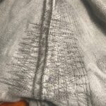 graue Jeanshose im Schritt repariert mit der Maschine
