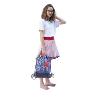 Mädchen in einem Wenderock, in der Hand eine Piraten-Beutelbag in Blau mit Nudeln, schwarzem Boden und roter Tasche